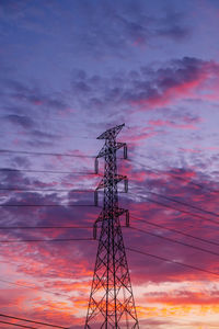 Low angle view of silhouette electricity pylon against sky during sunset