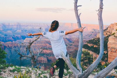 Full length of woman standing on tree trunk