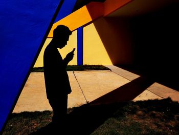 Side view of silhouette man walking against wall