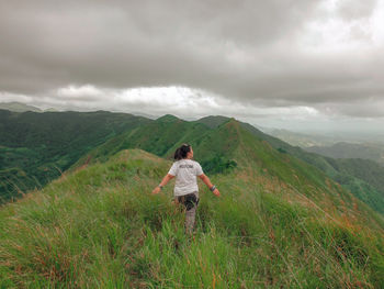 Rear view of man standing on land against sky