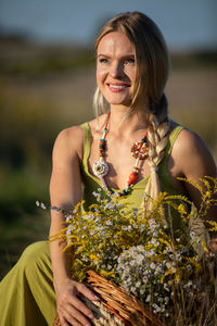 Portrait of young woman standing against plants