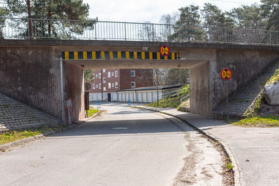 Low tram bridge over a snall road in the suburbs
