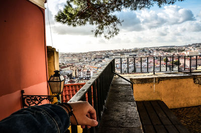 Man on railing against buildings in city