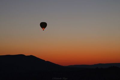 Silhouette hot air balloon against sky during sunset