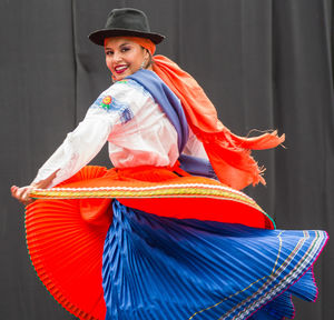 Portrait of smiling woman dancing on stage during traditional festival