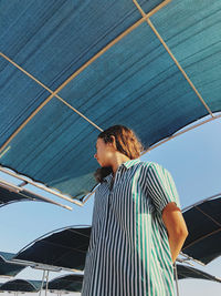 Low angle view of teenage girl standing against ceiling