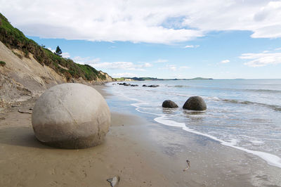 Rocks on beach against sky