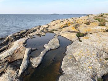 Rock formation on beach against sky