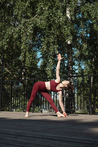 Woman exercising against trees