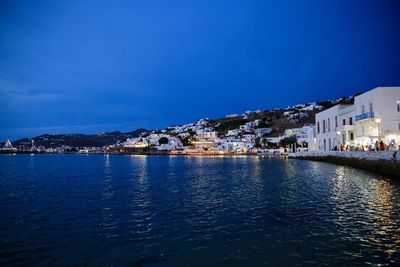 Town by sea against clear blue sky