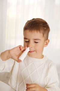 Little boy spraying medicine in nose, nose drops. toddler child using nasal spray. runny nose