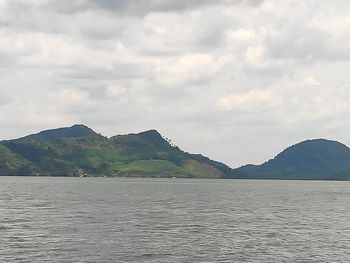 Scenic view of sea and mountains against sky