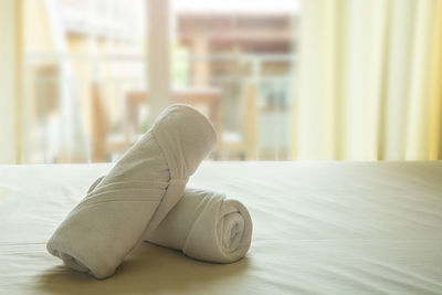 Towels rolled on bed in bedroom at home