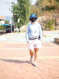 Full length rear view of man walking on footpath