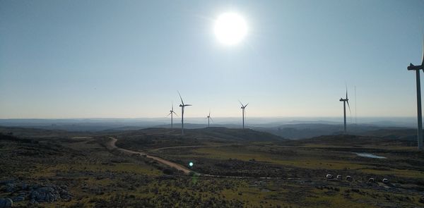 Wind turbines on land against sky