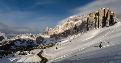 Panoramic view of people skiing on snowcapped mountain against sky