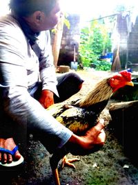 Side view of a man holding a bird