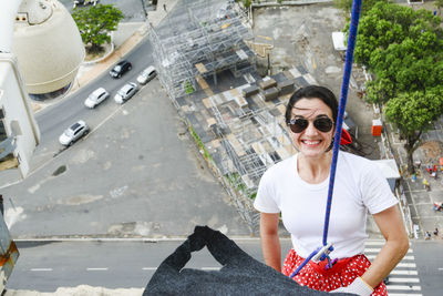 Caucasian woman wearing hero costume descending a tall building in rappel. salvador bahia brazil.