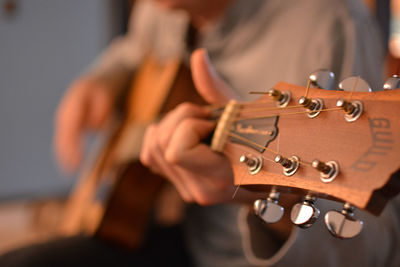 Midsection of man playing guitar