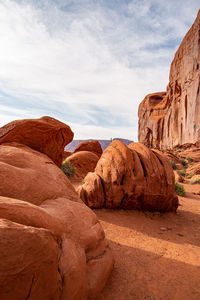 Rock formations on landscape against cloudy sky