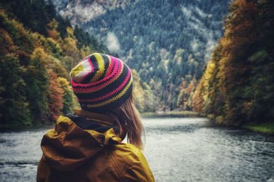 Rear view of woman by river during autumn