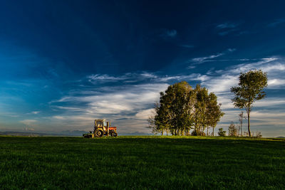 Tractor on field against blue sky