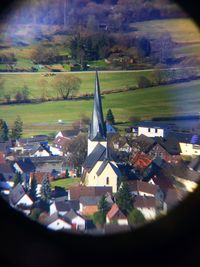 Tilt-shift image of houses in town against sky