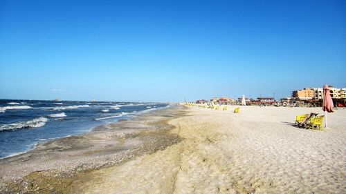 Panoramic view of beach against clear blue sky