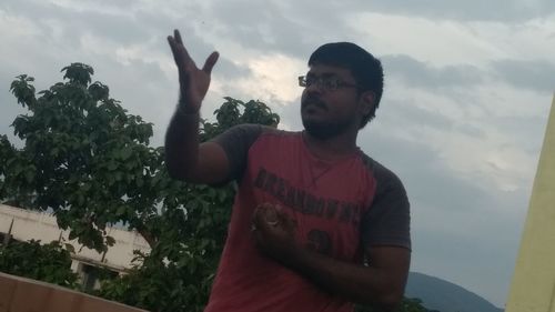 Young man standing against sky