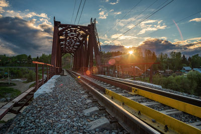 Railroad tracks against sky during sunset