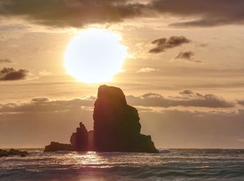 Evening bay. sharp rocks, black rounded boulders, stony beach, sand and dark sky.