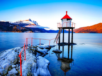 Scenic view of lake by snowcapped mountain against sky