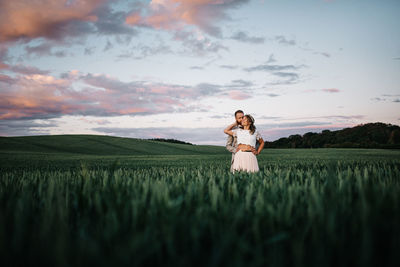 Woman standing on field against sky