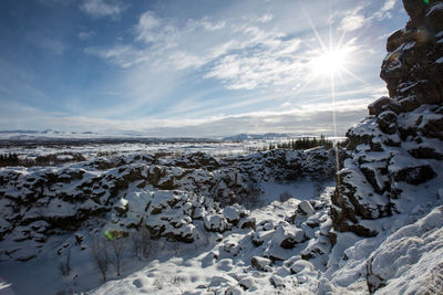 Snow covered land against sky during winter