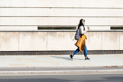 Full length of woman walking on footpath