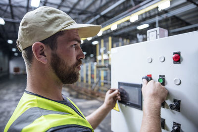 Worker operating machine in factory