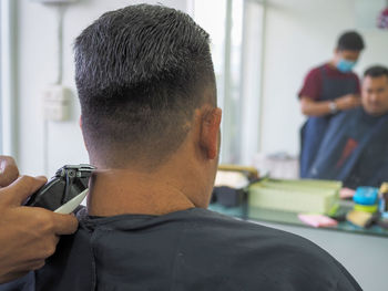 Midsection of barber cutting hair of customer