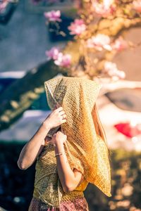 Close-up of woman holding pink flower