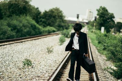 Rear view of man standing on railroad track