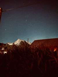 Houses on mountain against sky at night