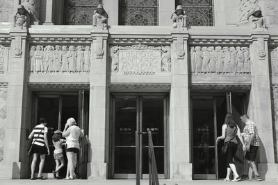 Rear view of people walking on building