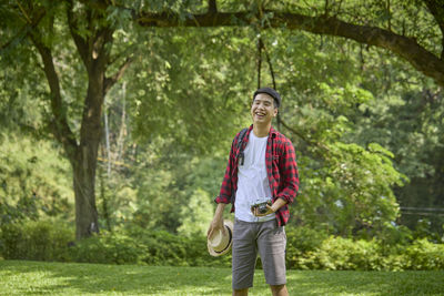 Full length of young man standing against trees