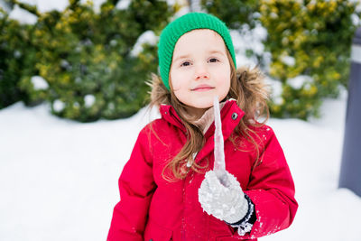 Portrait of girl holding icicle during winter