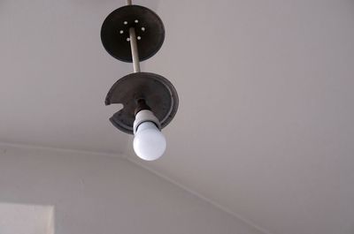 Low angle view of electric lamp hanging on ceiling