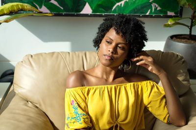 Black young woman relaxing at home on the sofa