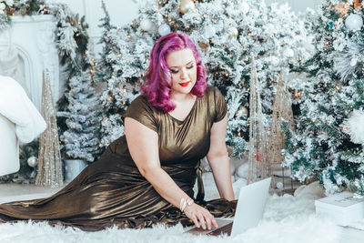 Portrait of young woman sitting on snow