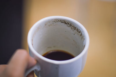 Close-up of hand holding coffee cup