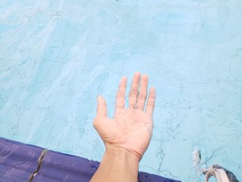 Low section of hand with people in swimming pool