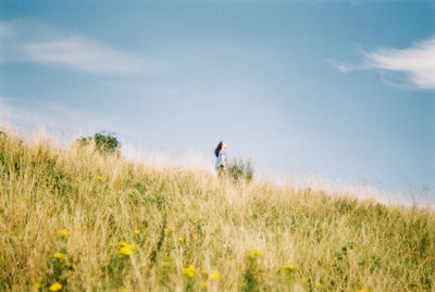 Woman standing on field against sky