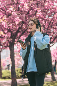 Young woman standing against trees